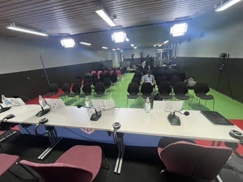 An empty press room at Ullevaal stadium before a match, with microphones ready on the table