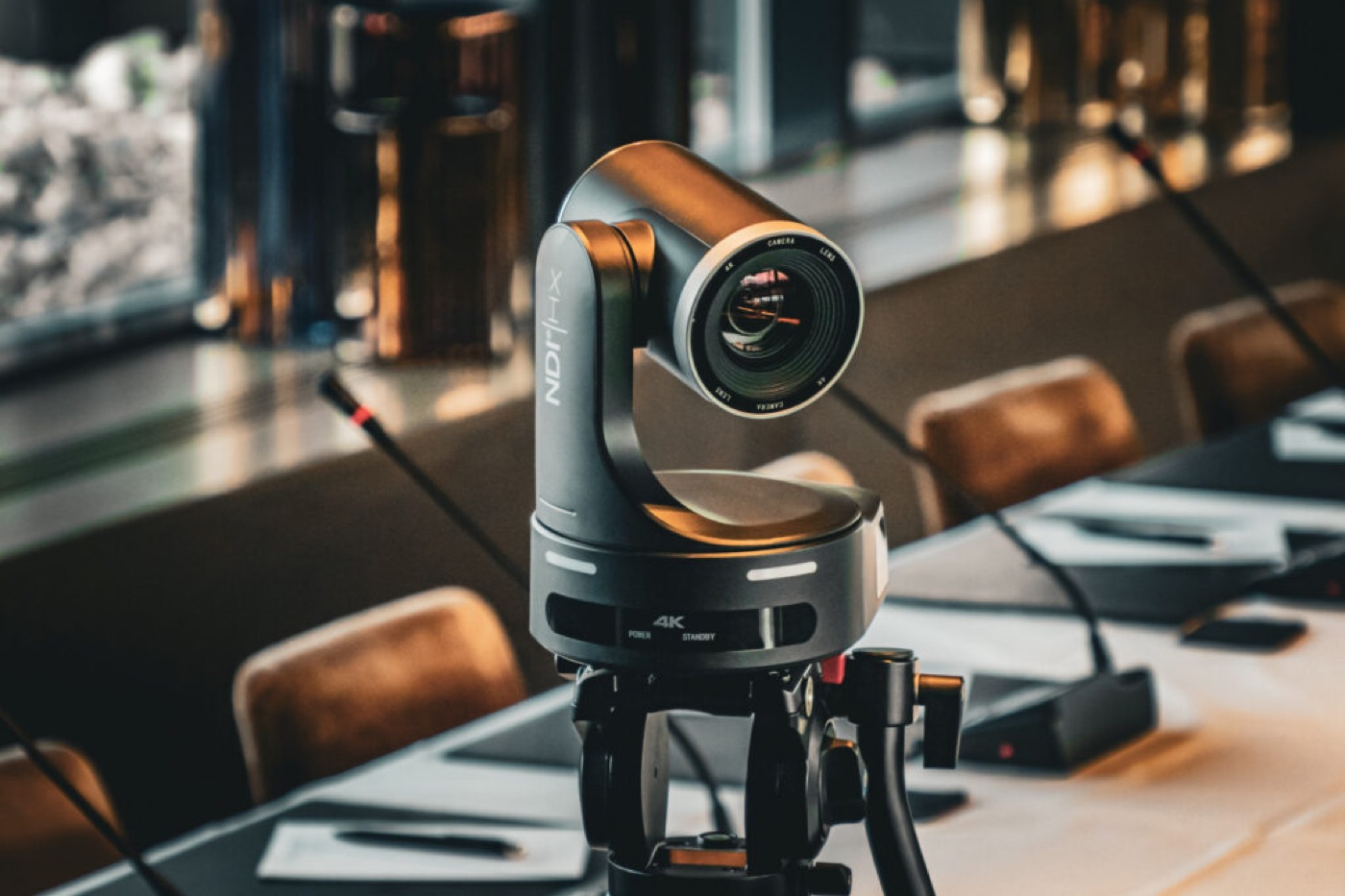 4K NDI-konferansekamera på stativ i konferansesal — sender lyd og video til remote tolk
